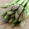 Jersey Knight asparagus tops resting on a wooden surface