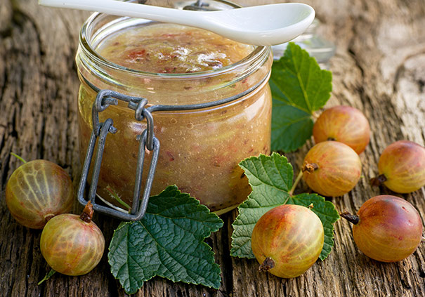 a jar of Gooseberry preserves on a wooden surface